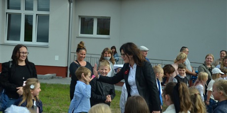 Powiększ grafikę: prezydent Dulkiewicz w otoczeniu uczniów, nauczycieli i rodziców na placu zabaw przy szkole