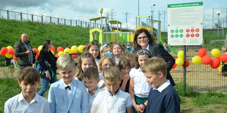 Powiększ grafikę: prezydent Dulkiewicz w otoczeniu uczniów na placu zabaw przy szkole