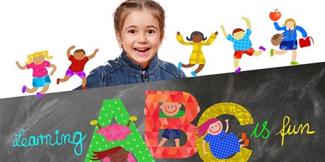 Powiększ grafikę: dziewczynka za tablicą, na której są litery i napis learning is fun