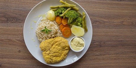 Powiększ grafikę: biały talerz obiadowy, na nim kotlet, ziemniak, porcja ryżu, kawałek brokuła i fasolka szparagowa