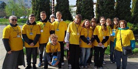 Powiększ grafikę: kwestujący uczniowie w żółtych koszulkach wraz z nauczycielami opiekunami