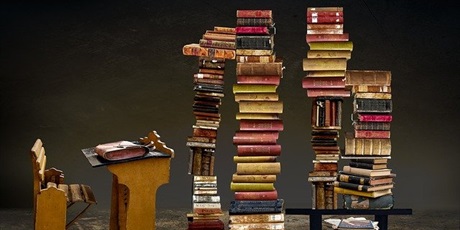 Powiększ grafikę: książki ułożone w stosy obok starej ławki szkolnej